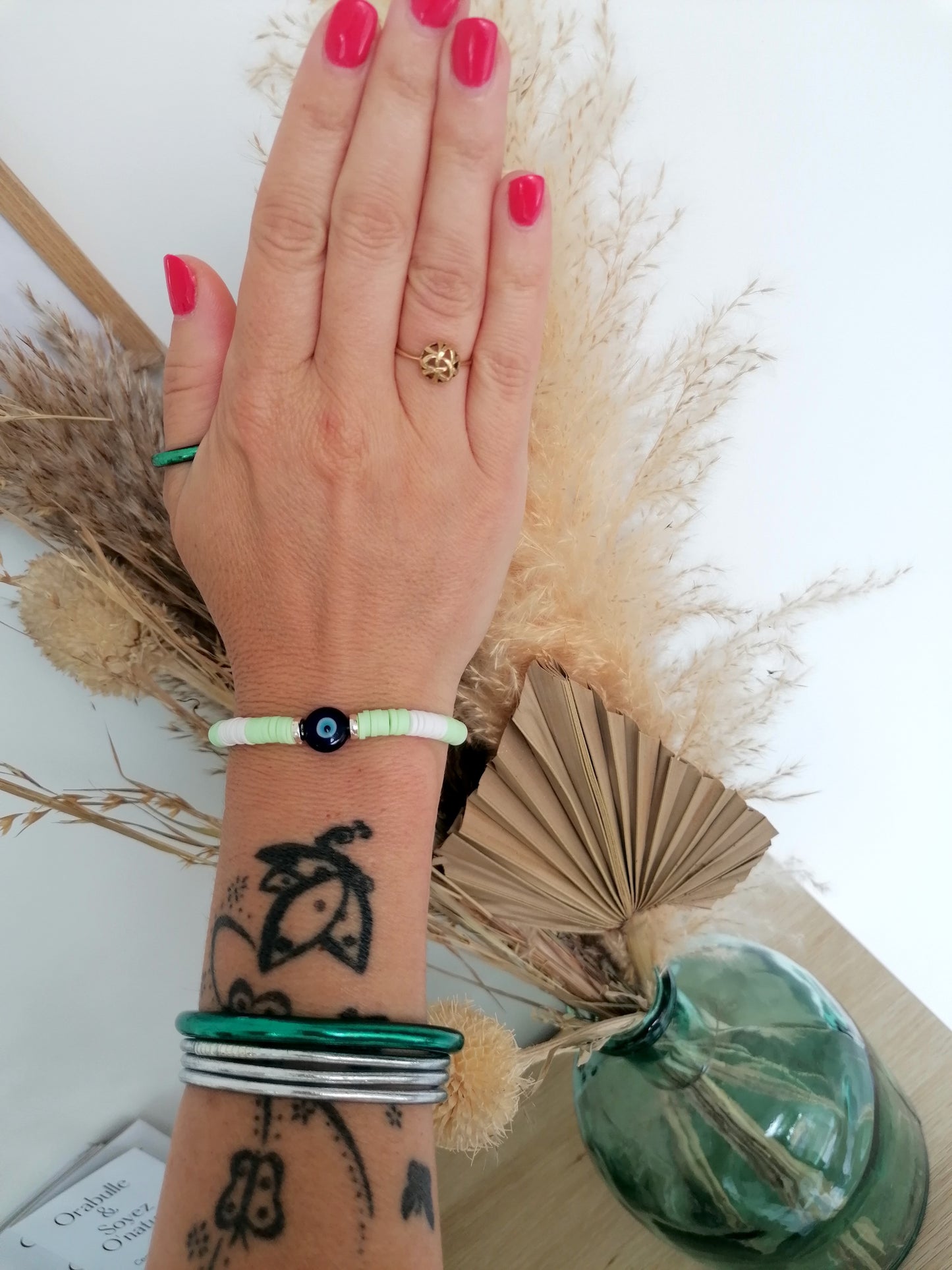 Bracelet en perles Heishi dans les tons verts clairs et blancavec symbole contre le mauvais œil - Protection, style, talisman